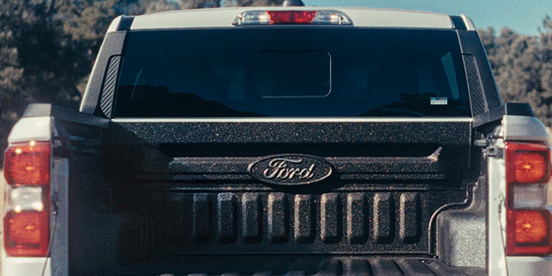 Rear view of a pickup truck with the tailgate open.