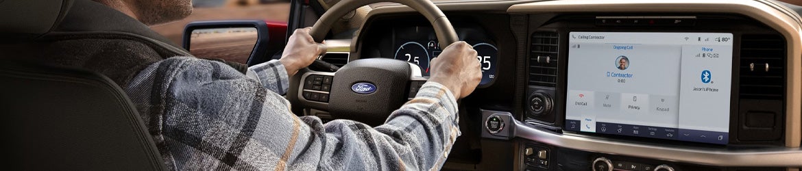 Driver with hands on the wheel driving a 2025 Ford F-150