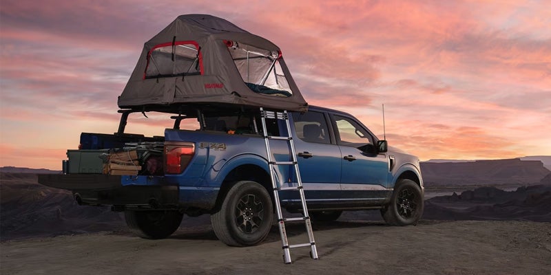 a 2025 Ford F-150 at a camp site with a tent on top