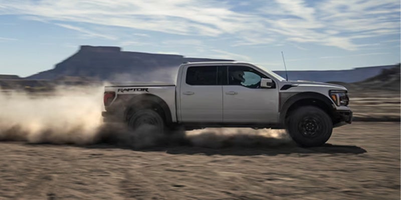 a 2025 Ford F-150 driving in the desert with dust